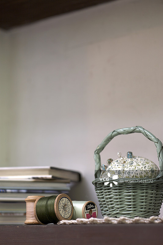 篮子里的针垫和架子上的线特写图片素材