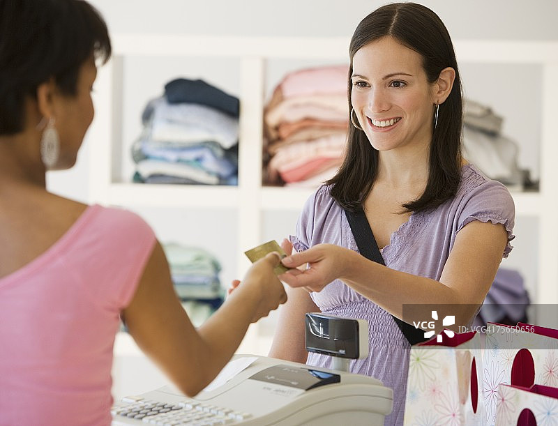 女人在服装店付款图片素材