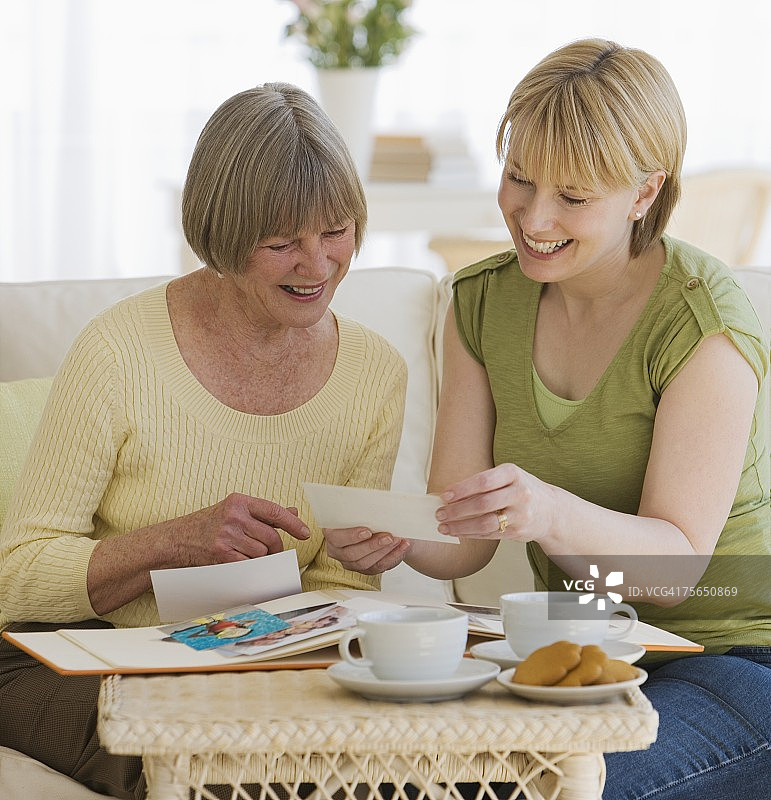 母亲和成年女儿正在看照片图片素材