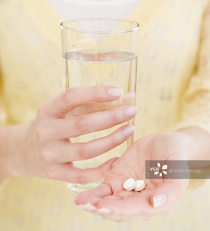 女人拿着水和药物图片素材