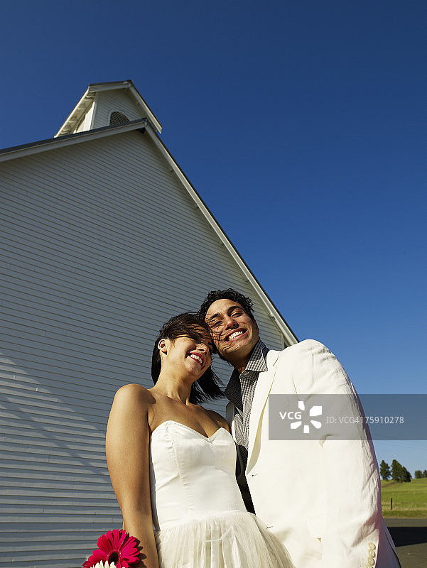 在教堂外微笑的新婚夫妇图片素材