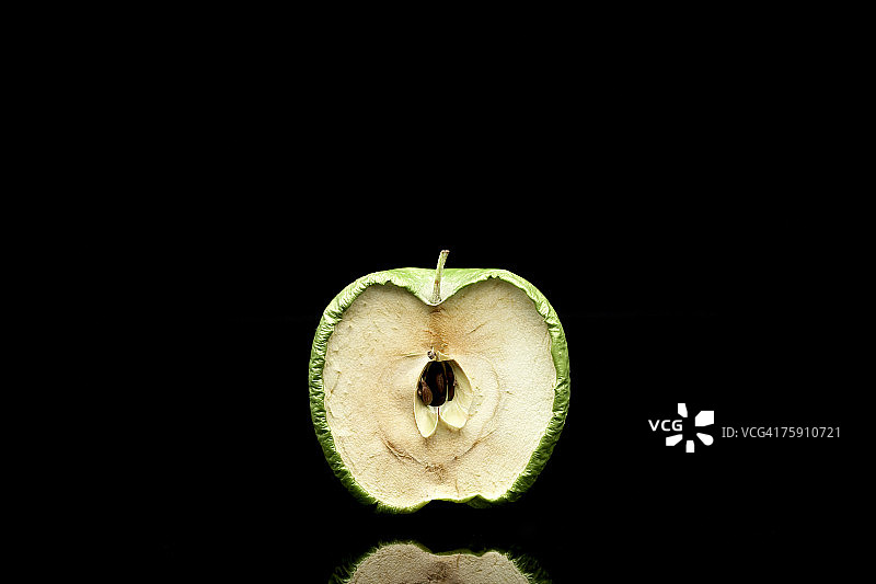 白色背景上切成两半的腐烂青苹果图片素材
