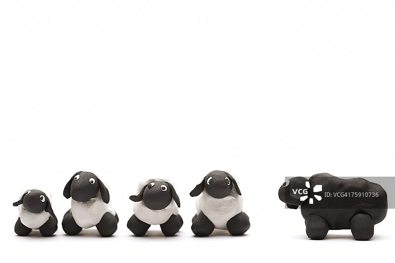 四只白色黏土羊和一只黑色黏土羊图片素材