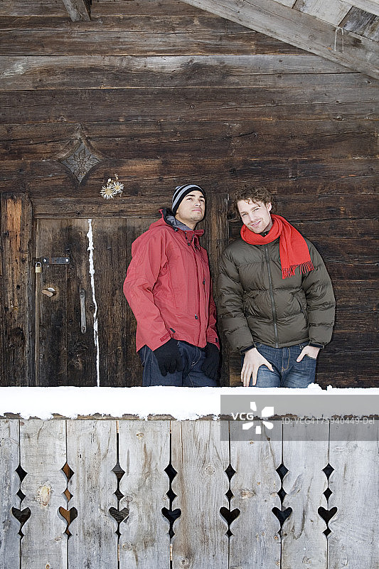 两名男子站在小屋旁图片素材