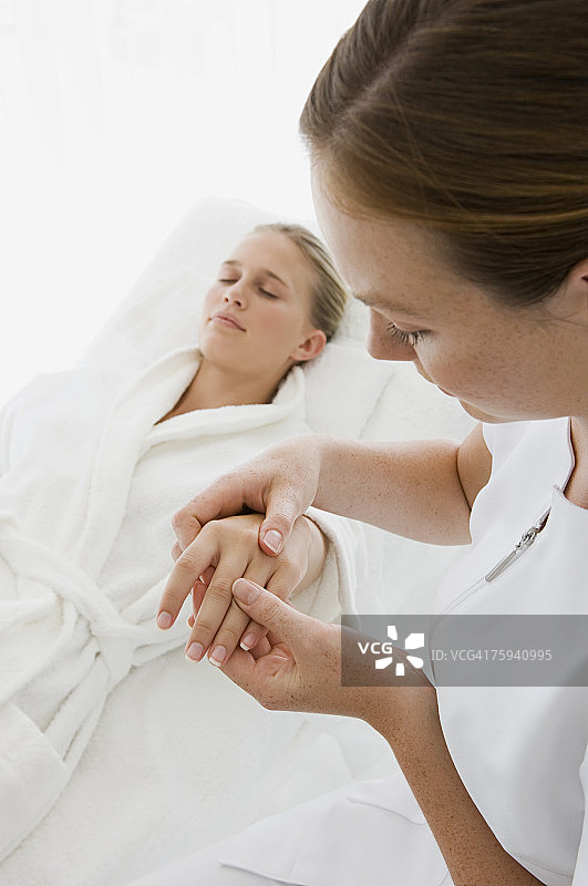 女理发师为年轻女人洗头和涂抹肥皂图片素材
