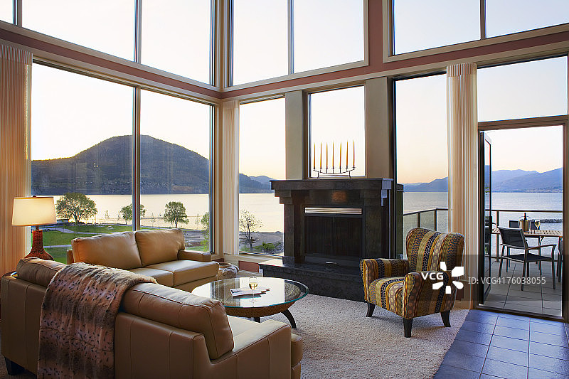 加拿大不列颠哥伦比亚省彭蒂克顿，日落时分可俯瞰大海的现代住宅客厅图片素材