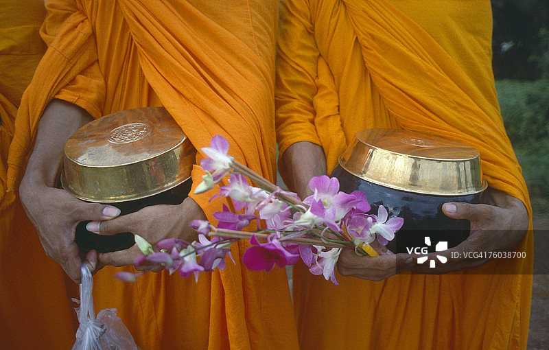 佛教僧侣手持钵和鲜花特写图片素材