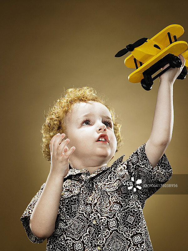2-4岁男孩举起玩具飞机图片素材