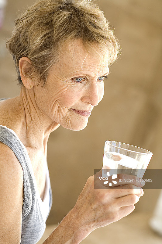 年长的女人手持一杯水图片素材