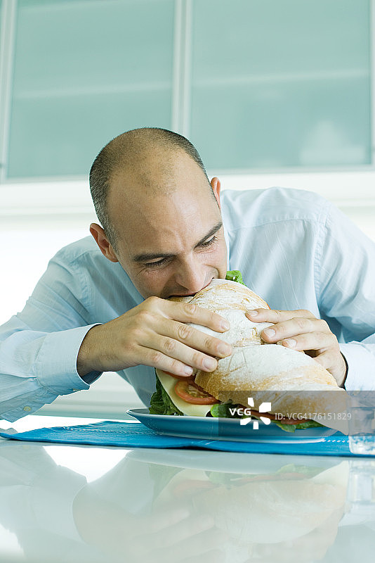 男人咬着大三明治图片素材
