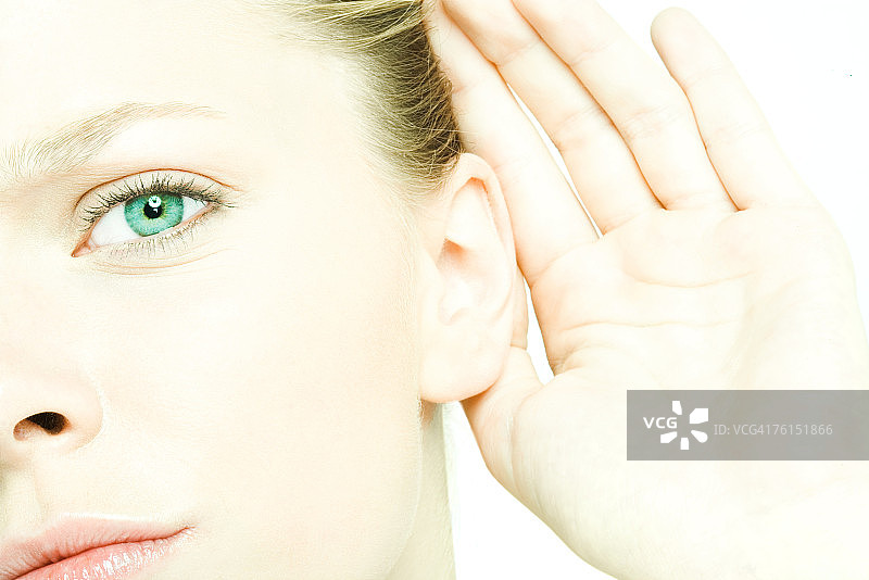 “十几岁的女孩手放在耳后，看着镜头，特写”图片素材