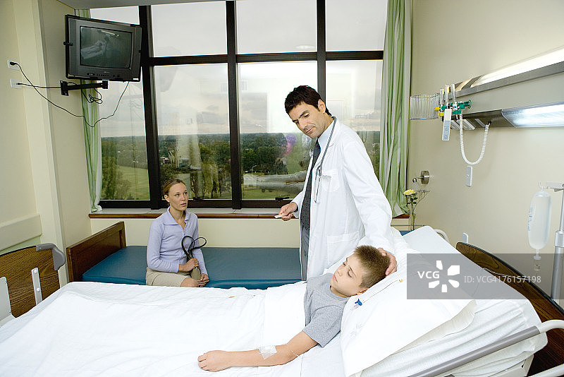 儿童躺在病床上，医生在一旁图片素材