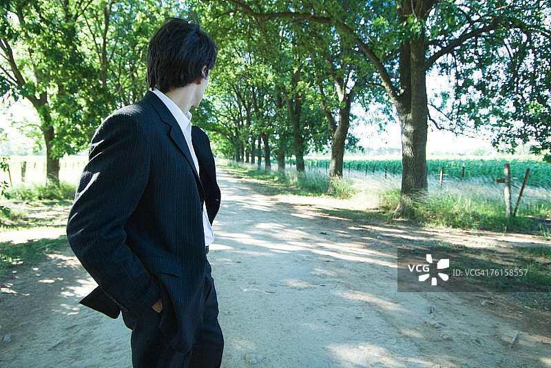 商人走在乡村小路回望图片素材