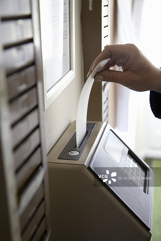 男人将时间卡插入计时器图片素材