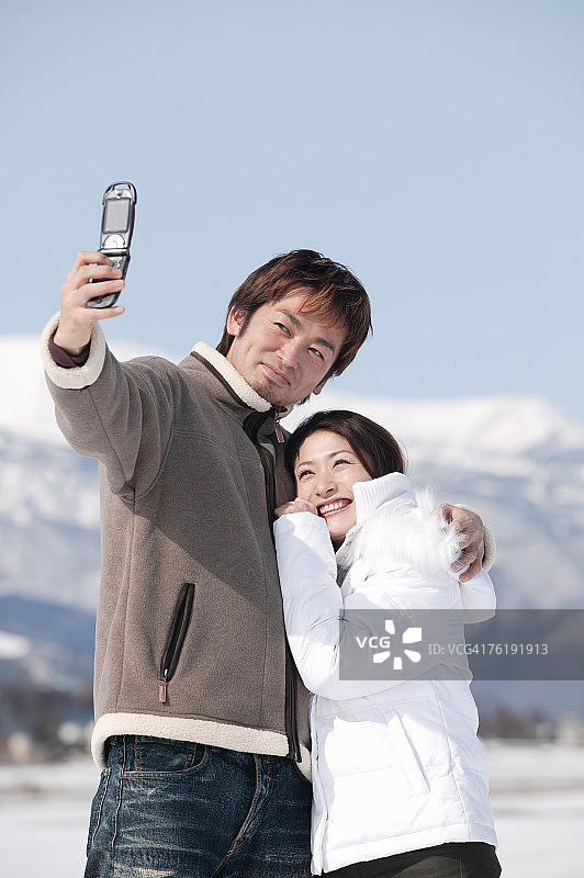 年轻情侣用手机拍照图片素材