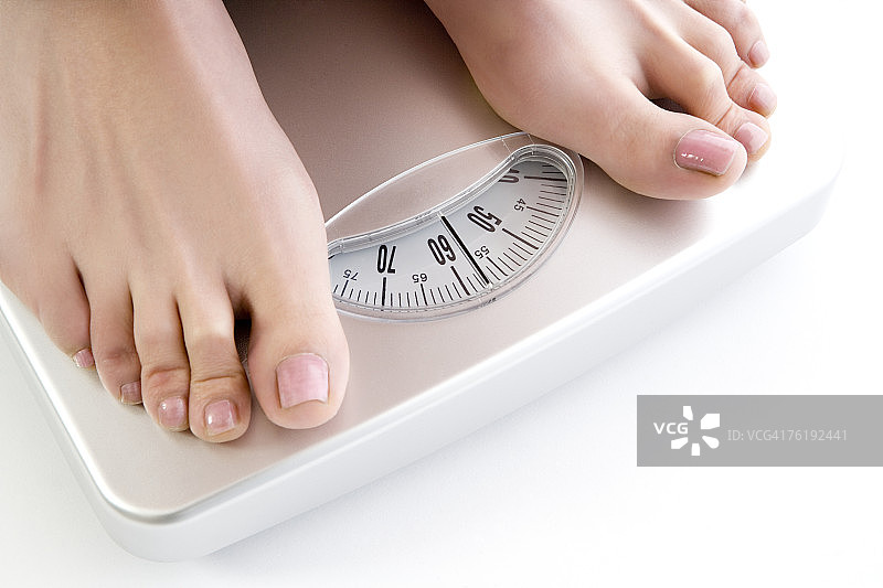 站在体重秤上的女人图片素材