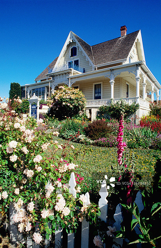 前景有花园鲜花的历史房屋，位于美国加利福尼亚州门多西诺图片素材