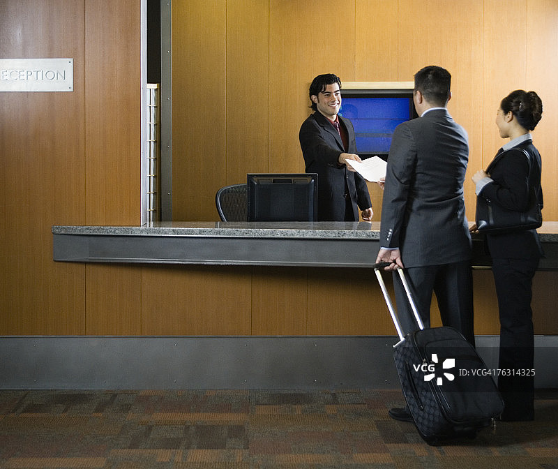 接待员在前台迎接商务旅客图片素材