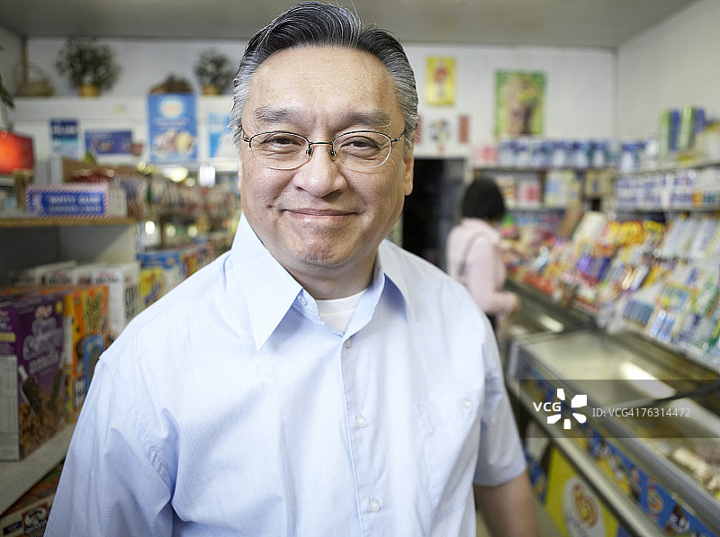 年长的男人在商店里微笑，肖像照图片素材