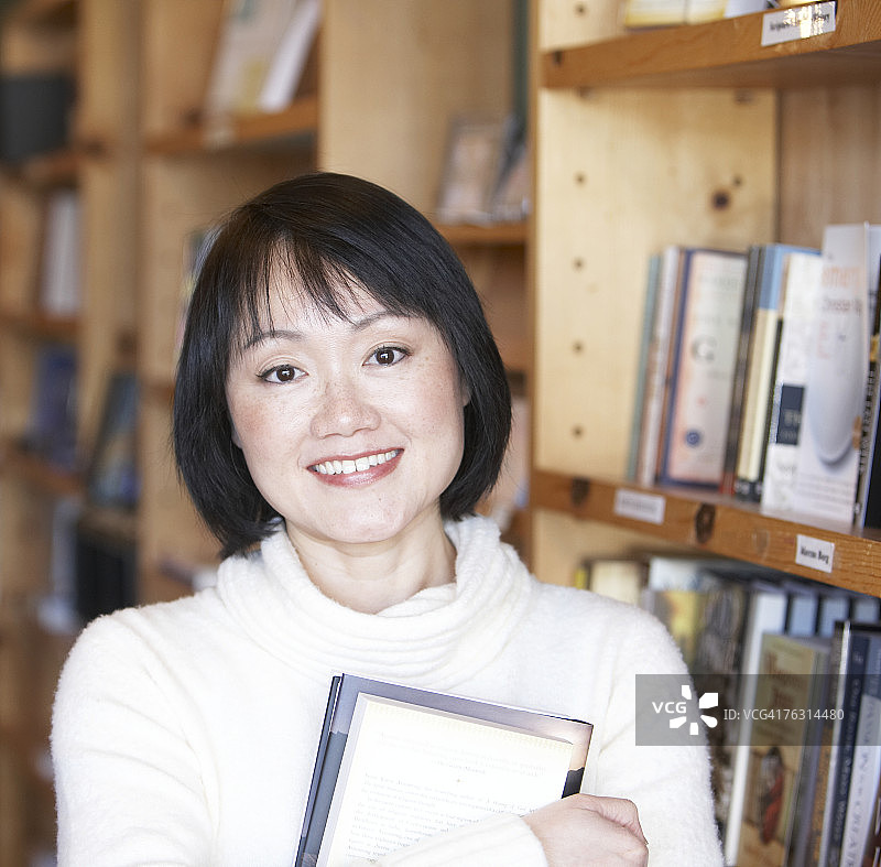 在书店里微笑的女人，肖像图片素材