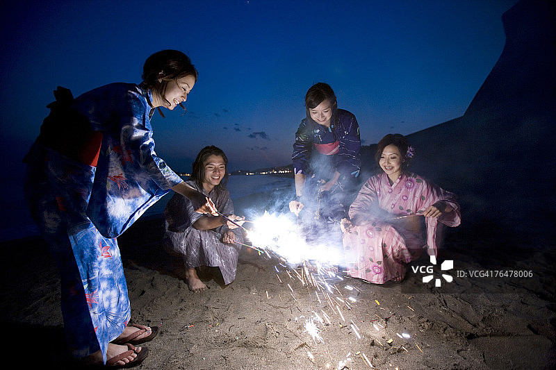 一小群人在海滩上玩仙女棒图片素材