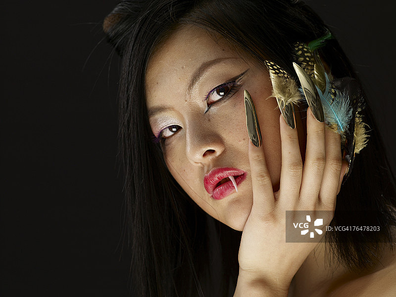指甲上有羽毛和尖牙的女人图片素材