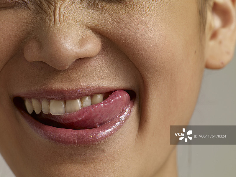 年轻女人的嘴巴，舌头舔舐嘴唇，特写图片素材