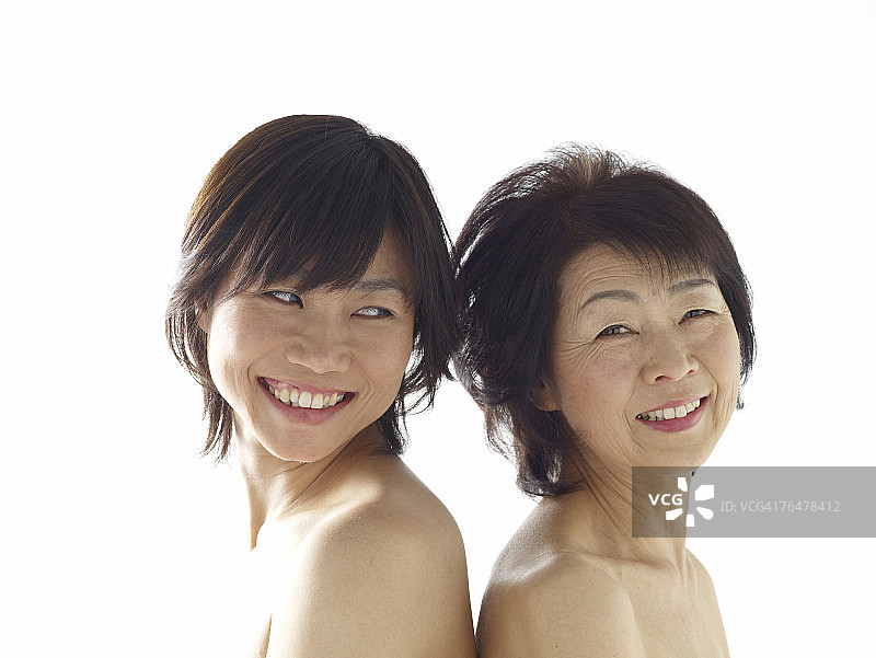 一位中年妇女和一位年轻女子，背靠背站立图片素材
