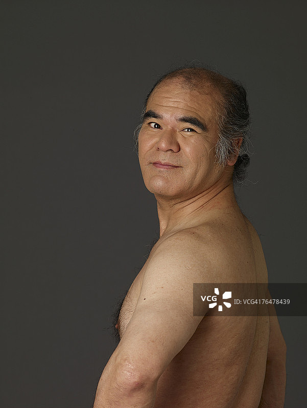 转过身面对镜头的无上衣男人肖像图片素材