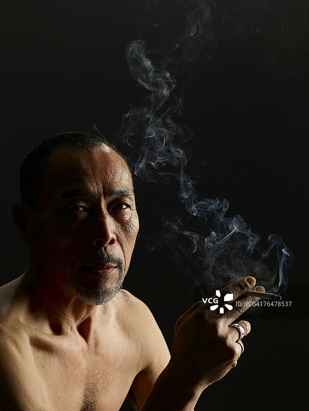 中年男人拿着一支香烟图片素材