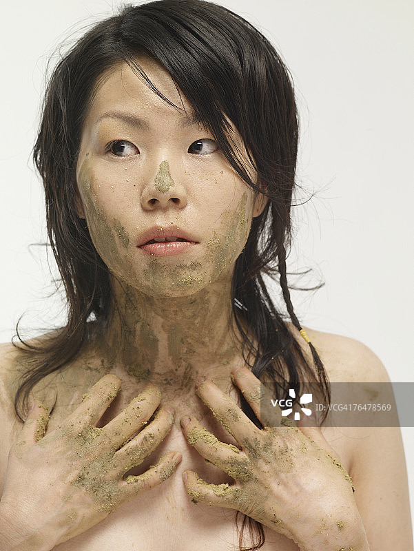 手和脸沾满泥巴的女人图片素材