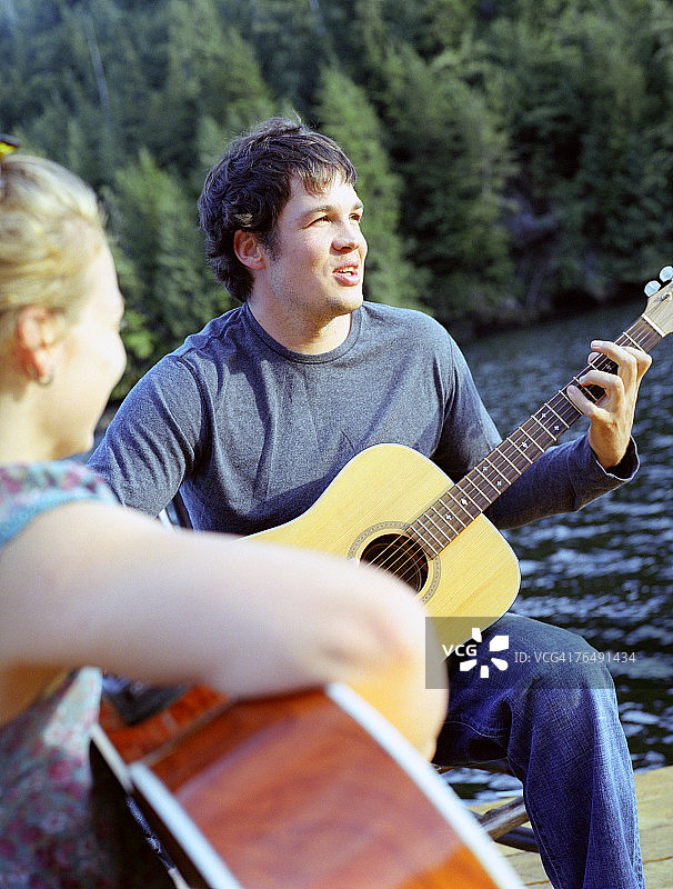 男人在加拿大不列颠哥伦比亚省的尼莫湾码头和女人一起弹吉他图片素材