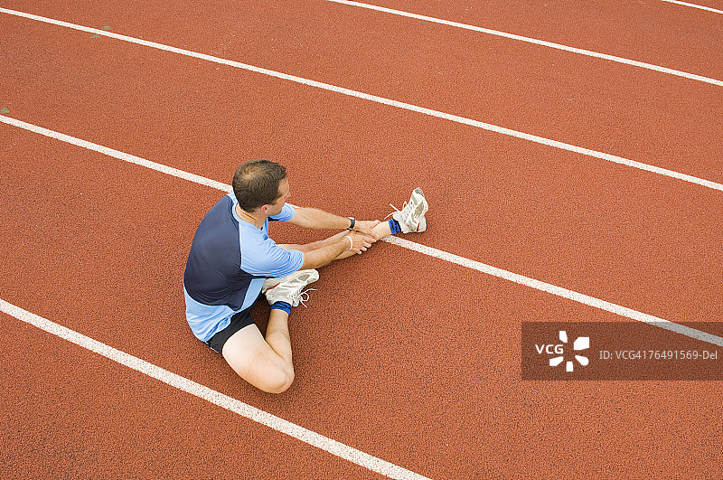 男子在科林斯堡的跑道上伸展身体，科罗拉多州图片素材
