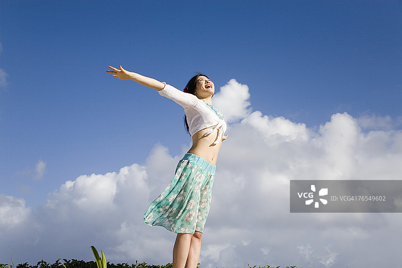 在户外伸展身体的年轻女人，侧视图图片素材