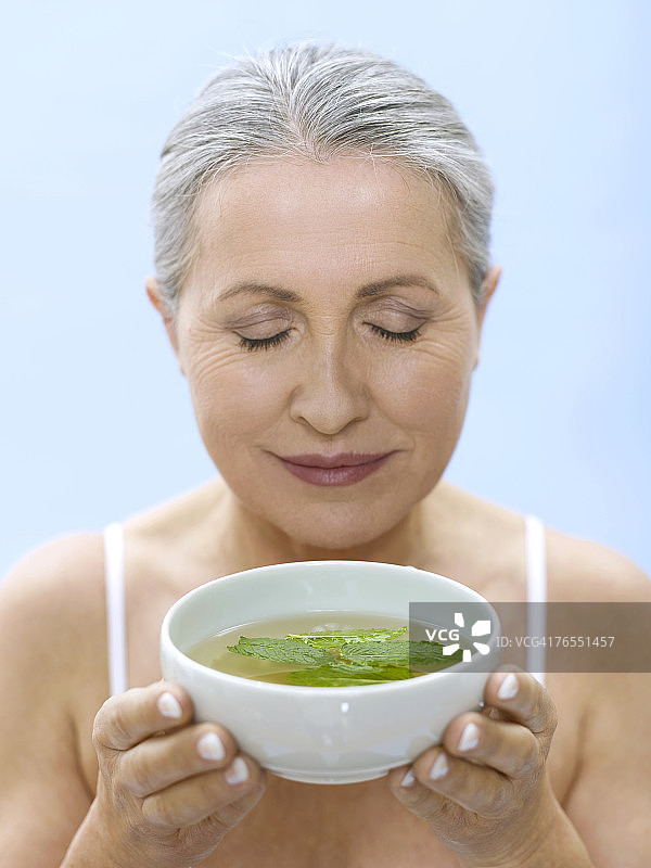 手捧茶碗的年长女性肖像图片素材