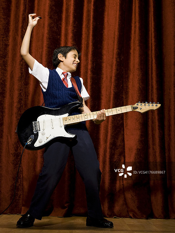 在舞台上弹电吉他的男孩图片素材