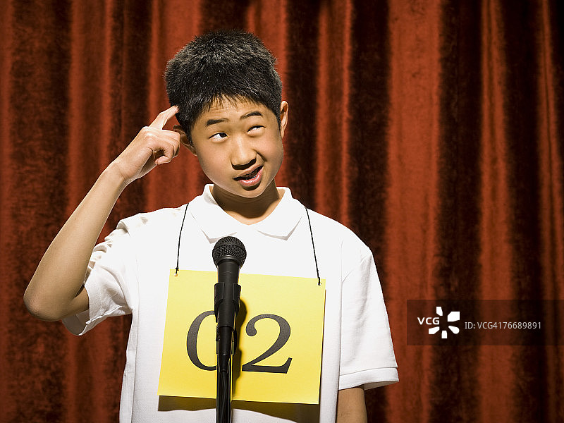 男孩站在麦克风前思考图片素材