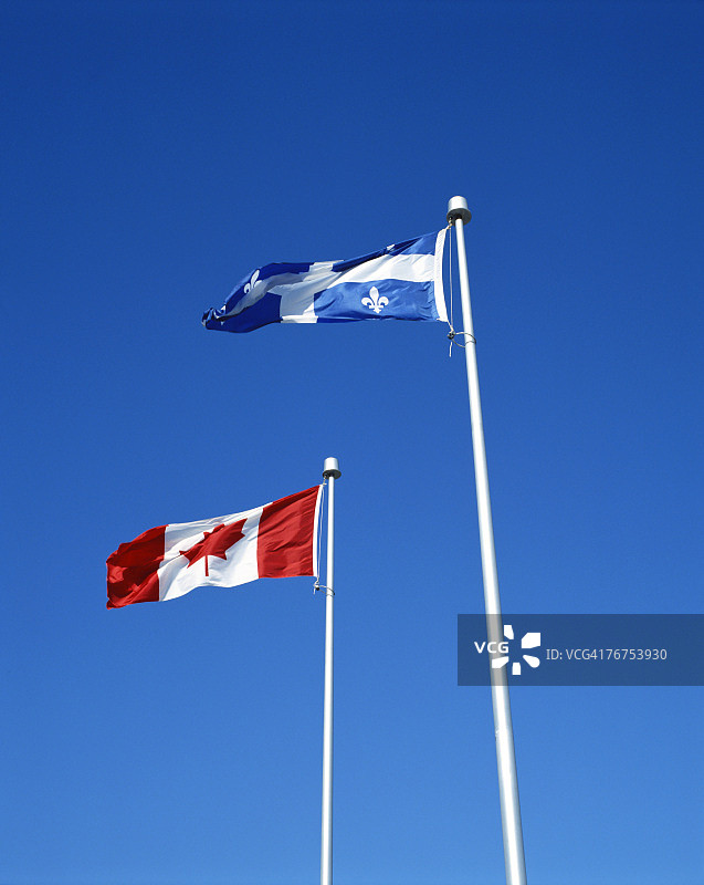 加拿大和魁北克旗帜与湛蓝天空图片素材