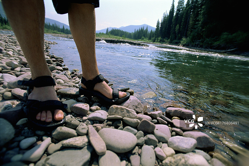 男人站在溪流岩石上的脚，大熊荒野图片素材