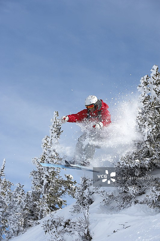 奥地利萨尔巴赫：滑雪者在树林中跳跃图片素材