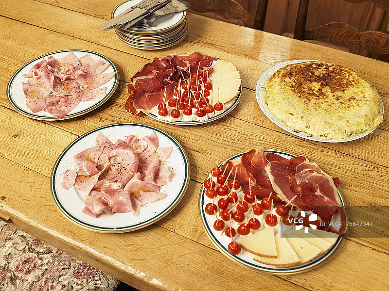 餐桌上的五盘熟肉、奶酪和玉米饼图片素材
