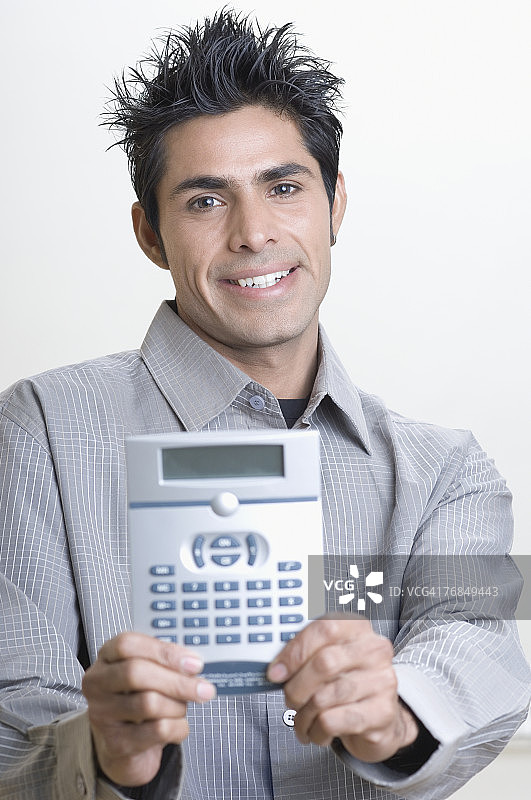拿着计算器的年轻男人肖像图片素材