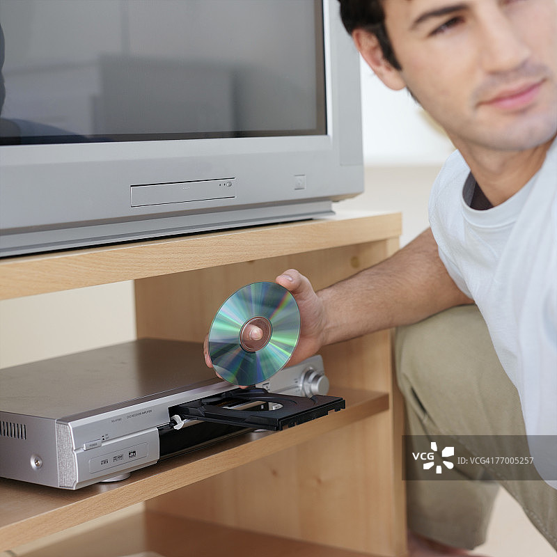 男人将DVD放入DVD播放机图片素材