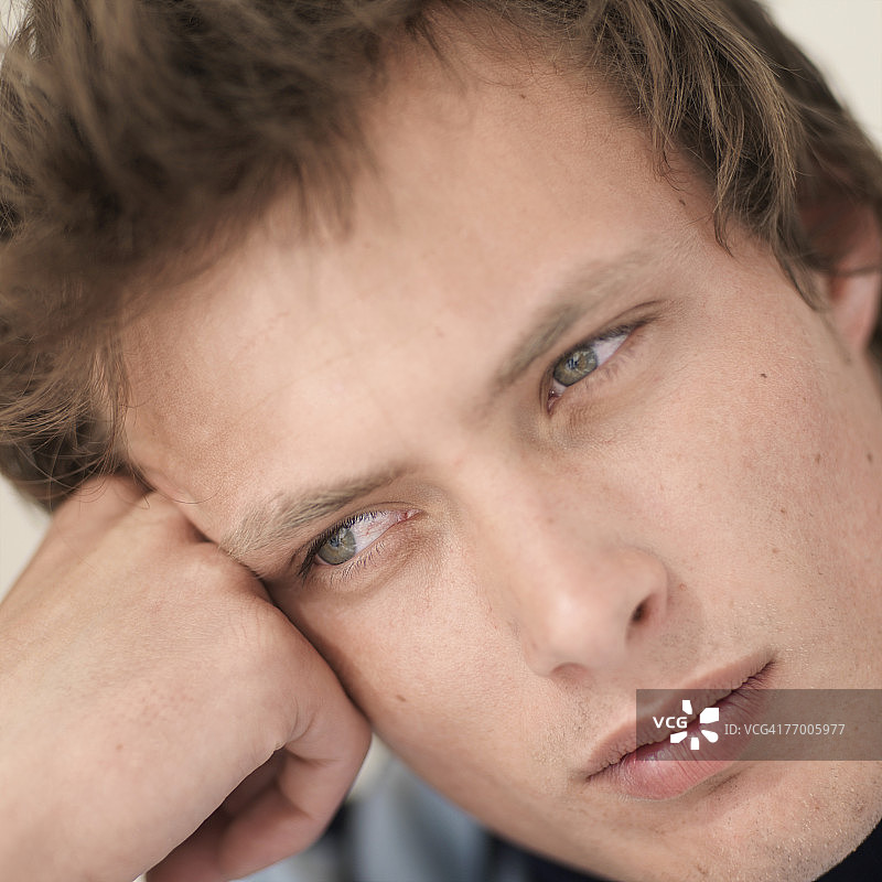 年轻男人手托头特写图片素材