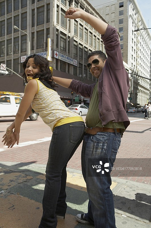 在路上跳雷鬼舞的年轻情侣侧面照图片素材