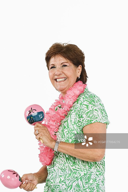 年长女人侧面轮廓，演奏沙锤并微笑图片素材