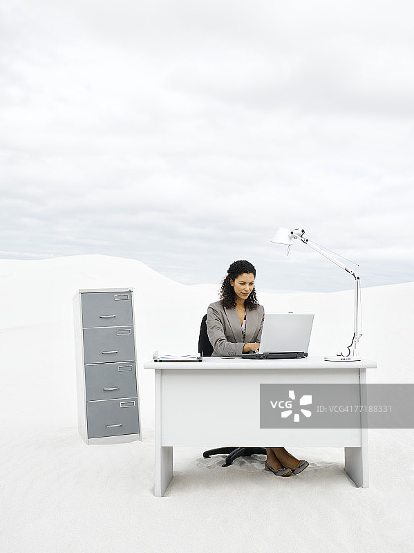 在荒郊野外办公桌前的女商人图片素材