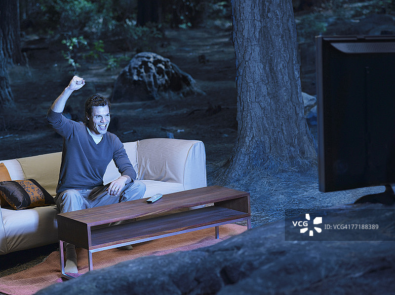 男人在户外的树林里看电视图片素材