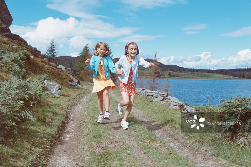 两名女孩在湖边公路上跑步图片素材