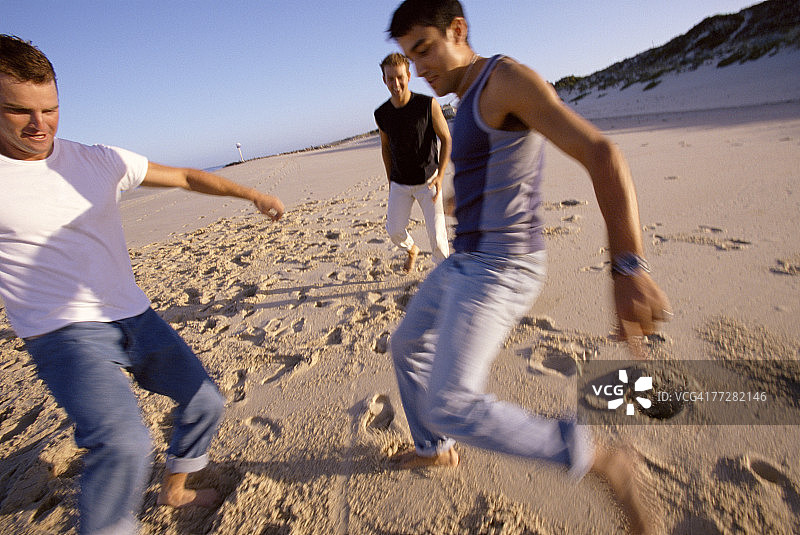 三名男子踢足球图片素材